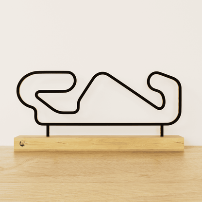 Minimalistisch Circuit de Barcelona-Catalunya silhouet van zwart staal op een naturel eikenhouten voetstuk.