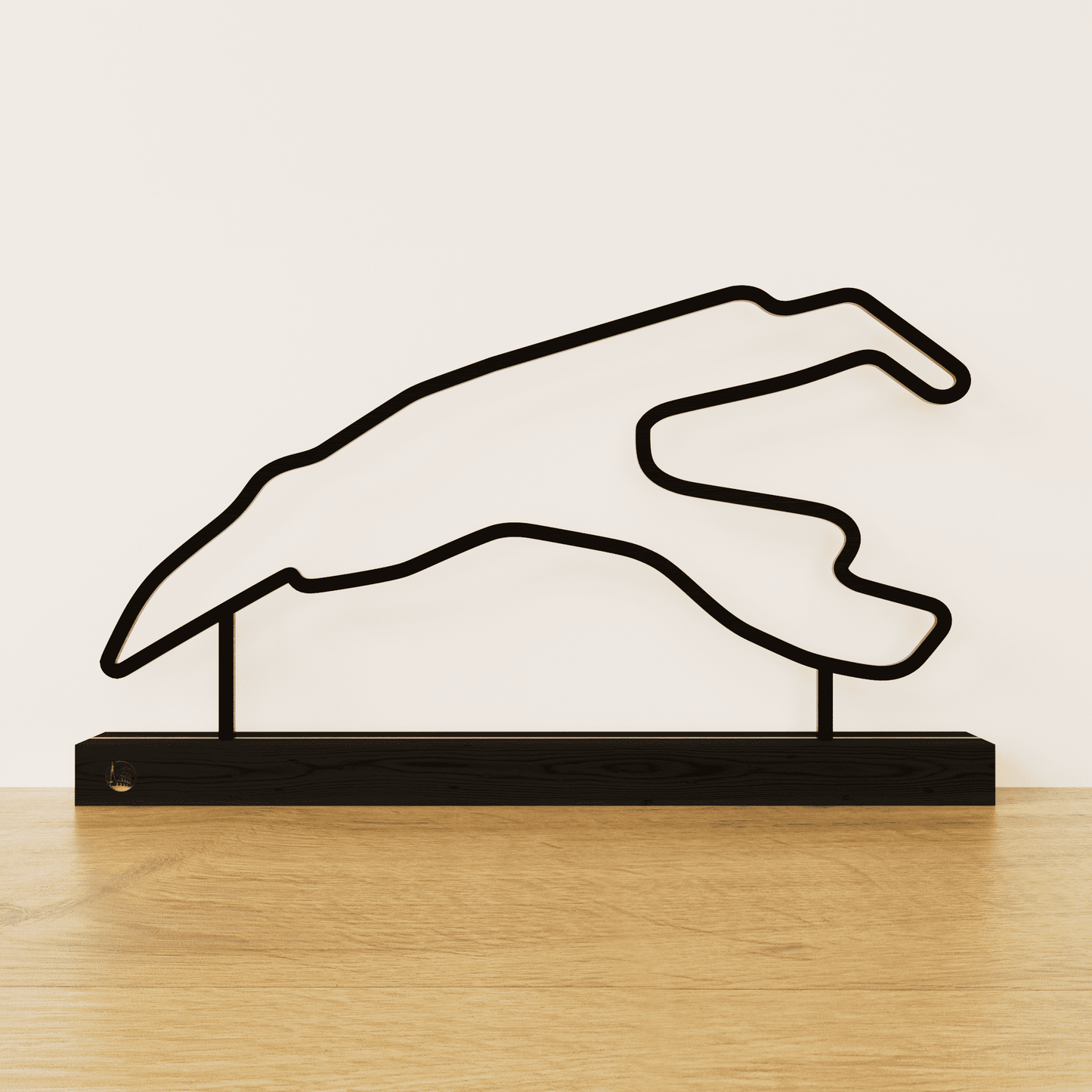 Minimalistisch Spa-Francorchamps circuit silhouet van zwart staal op een matzwart eikenhouten voetstuk.