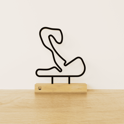 Minimalistisch Circuit Zandvoort silhouet van zwart staal op een naturel eikenhouten voetstuk.