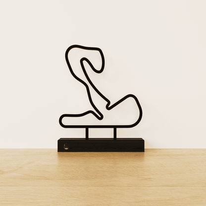 Minimalistisch Circuit Zandvoort silhouet van zwart staal op een matzwart eikenhouten voetstuk.