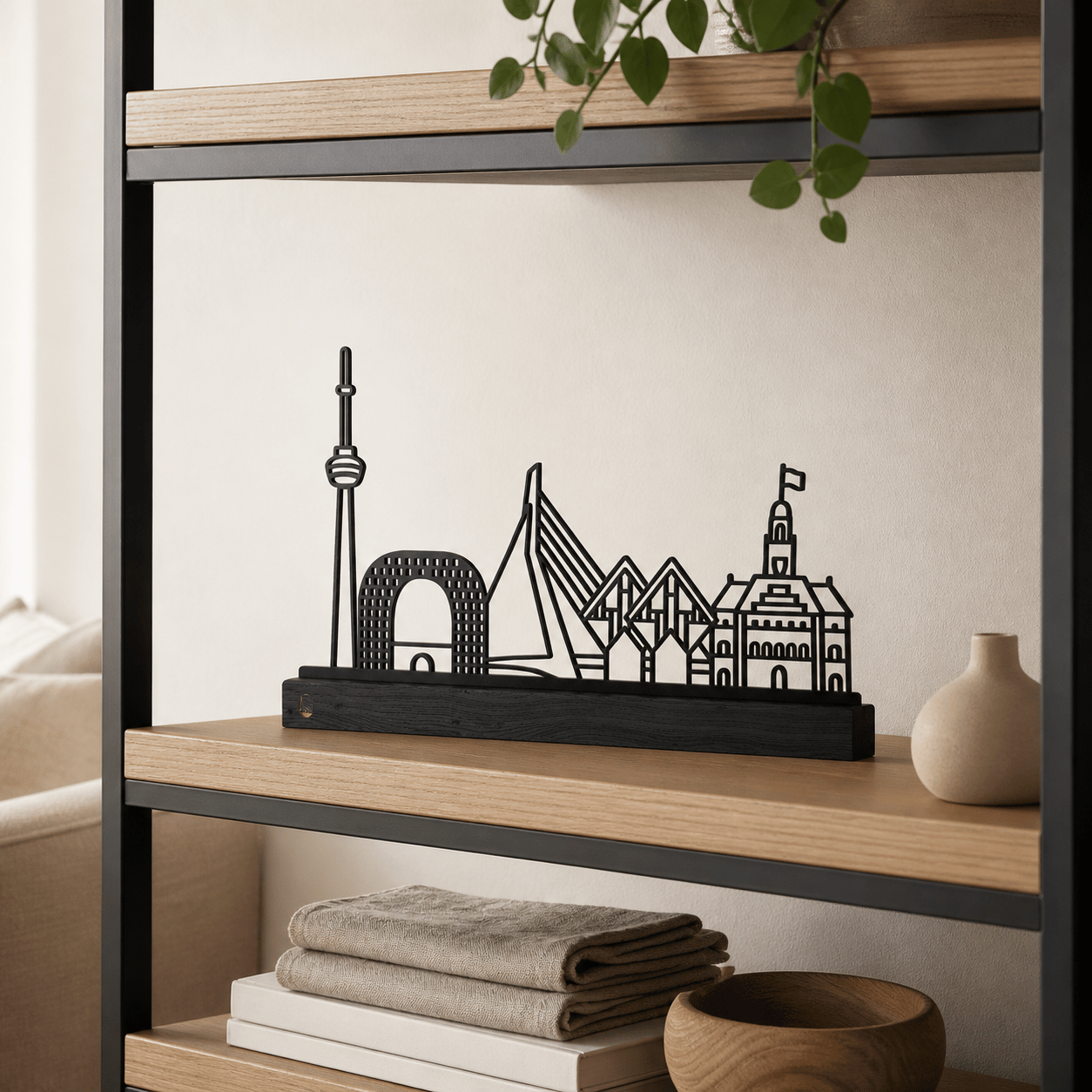 Het stalen silhouet van de skyline van Rotterdam op een zwart eikenhouten voetstuk.